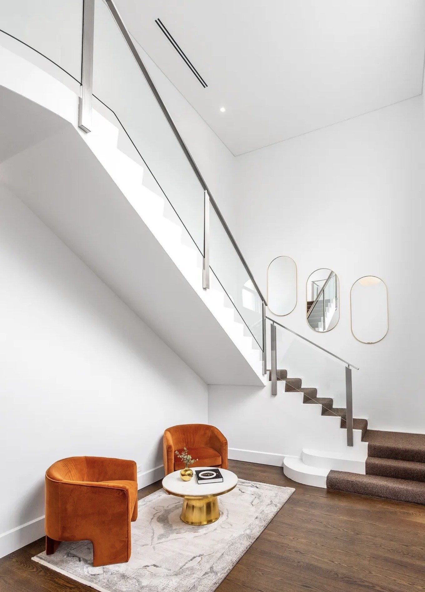 staircase-and-small-living-area-orange-chairs